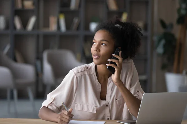 Drömmande ung afrikansk amerikansk kvinna som håller telefonsamtal. — Stockfoto