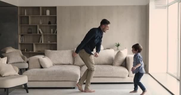 Alegre padre e hijo pequeño bailando en casa — Vídeo de stock