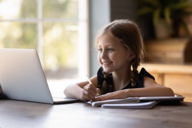 Mutlu tatlı çocuk, evde ders çalışıyor, ödevlerini yapıyor.