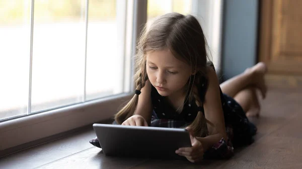 Focused pre school kid doing home task online — стоковое фото