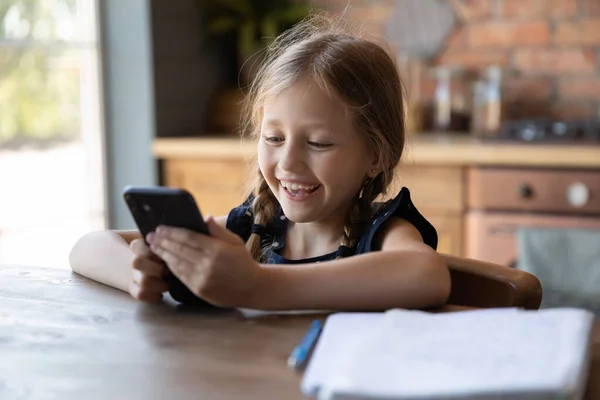 Happy little girl using cellphone for video call, speaking — Stock Photo, Image