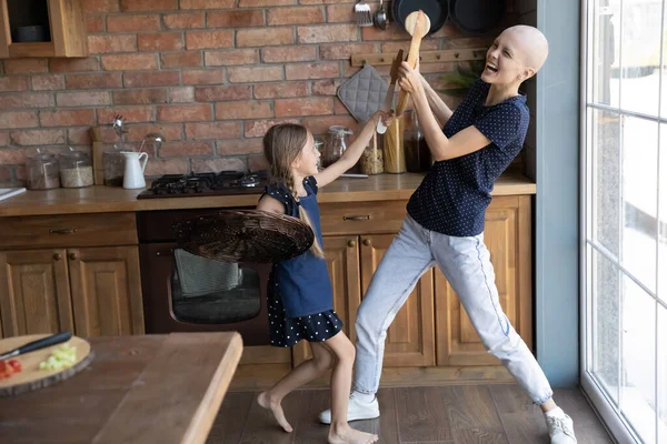Alegre emocionada madre e hija peleando con la cocina —  Fotos de Stock