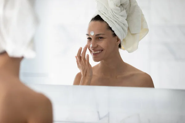 Happy millennial girl enjoying home spa, applying cream — Stock Photo, Image