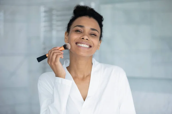 Ritratto di felice giovane razza mista Donna nera che applica il trucco — Foto Stock