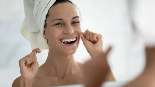 Happy young woman wrapped in bath towel flossing white healthy — Stock Photo, Image