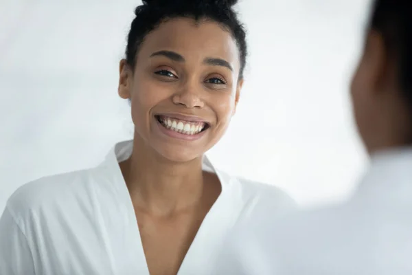 Spiegelbild eines aufgeregten, glücklichen schwarzen Millennial-Mädchens im Bademantel — Stockfoto