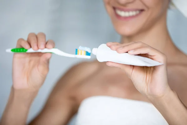 Happy woman brushing teeth with toothy smile, squeezing mineral toothpaste — Stock Photo, Image