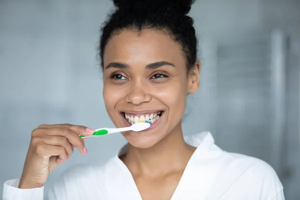 Glücklich teen afroamerikanisch mädchen im bademantel putzen weiße zähne — Stockfoto