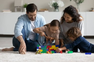 Mutlu çok ırklı ebeveynler küçük çocuklarla oynar.