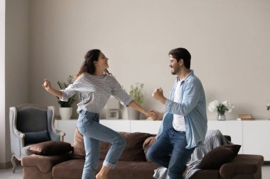 Coşkulu çok ırklı çift evde birlikte dans ediyor.