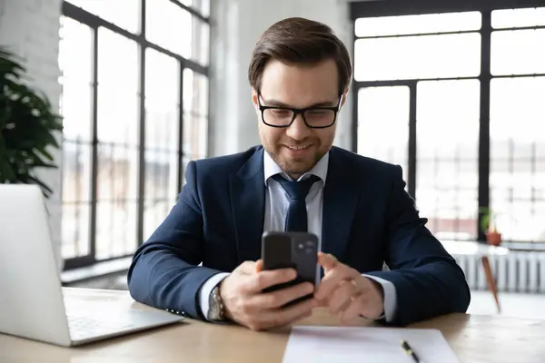 Gelukkig zakenman met behulp van online app op smartphone op kantoor — Stockfoto