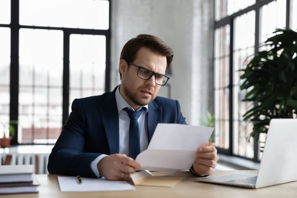 Orolig förvirrad affärsman läsa brev på arbetsplatsen — Stockfoto