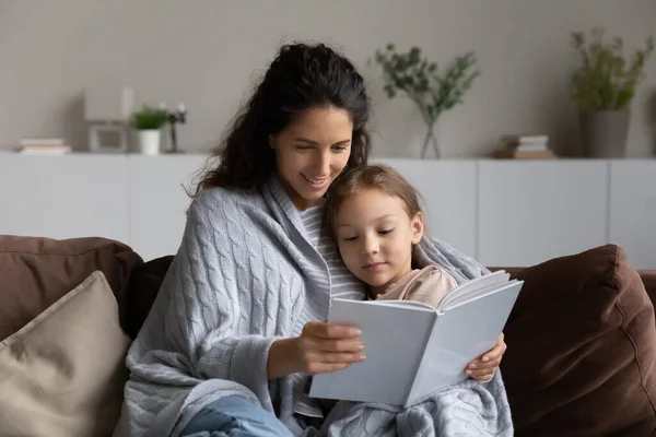 Amoroso mãe hispânica e filha relaxar leitura livro — Fotografia de Stock