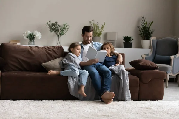 Loving Caucasian father read book to small children