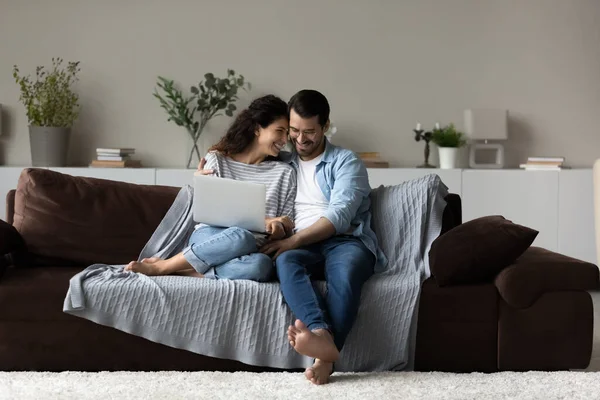 Glückliches multiethnisches Paar entspannen zu Hause mit Laptop — Stockfoto