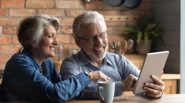 Mutfakta masa aleti kullanan mutlu, olgun bir çift.