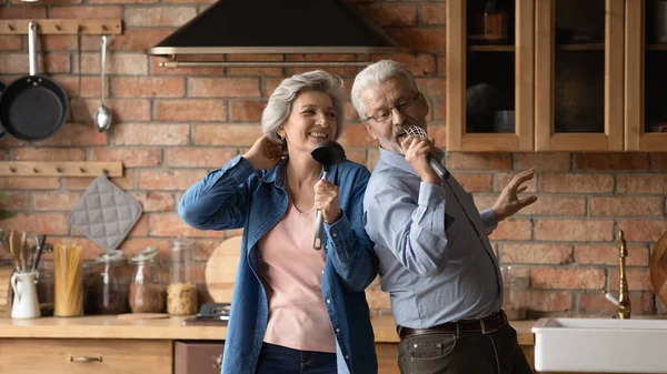 Счастливые супруги средних лет танцуют на кухне — стоковое фото