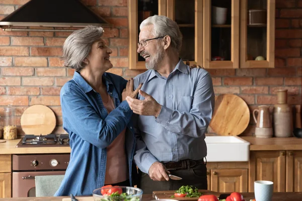 Joyful casal maduro de vegans cozinhar jantar juntos em casa — Fotografia de Stock