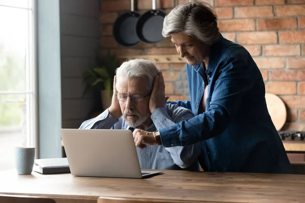 Frun ger enkel vägledning till förbryllade gamla make använda laptop — Stockfoto