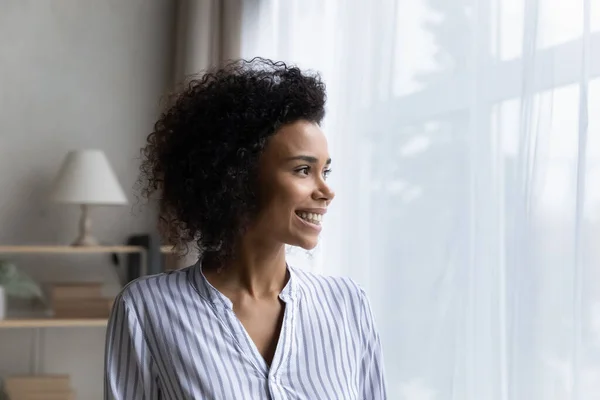 Glimlachende Afro-Amerikaanse vrouw kijken in afstand dromen — Stockfoto