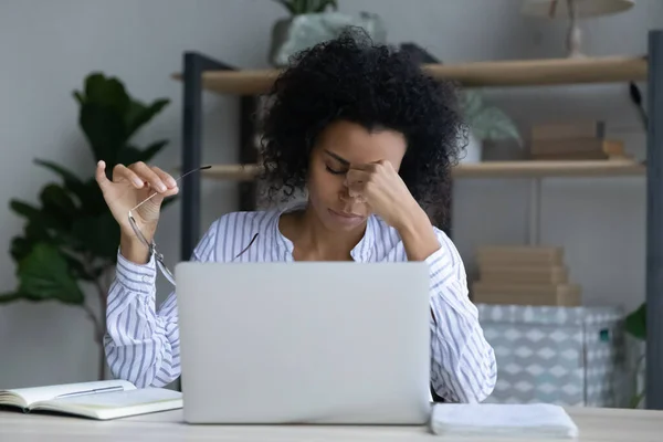 Trabajadora afroamericana cansada sufre de dolor de cabeza —  Fotos de Stock