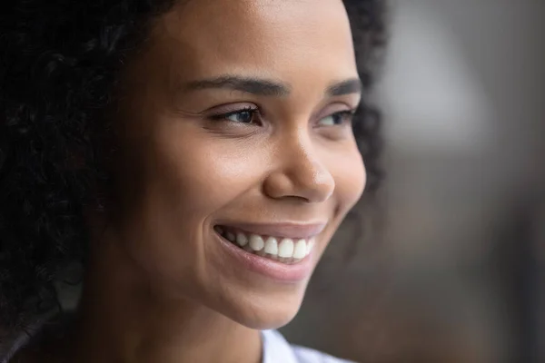 Nahaufnahme einer lächelnden Afroamerikanerin, die in die Ferne blickt — Stockfoto