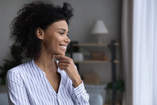 Sonriente mujer afroamericana mira a lo lejos soñando — Foto de Stock