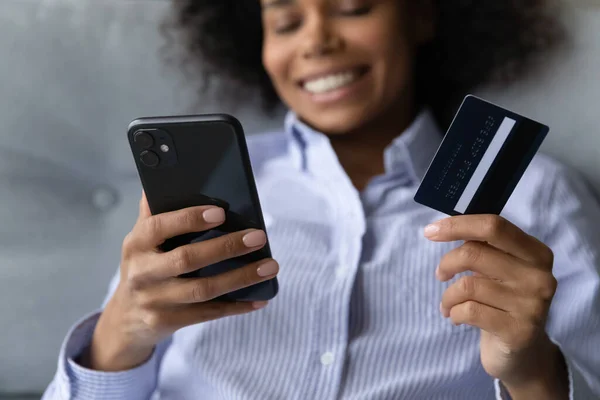 Lachende biraciale vrouw online winkelen op de smartphone — Stockfoto