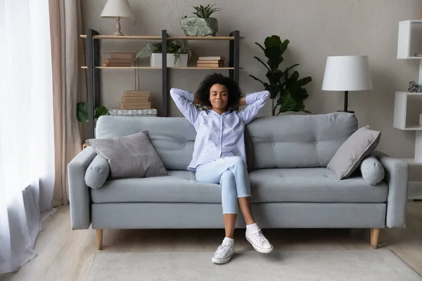 Heureuse femme afro-américaine se détendre sur le canapé à la maison — Photo