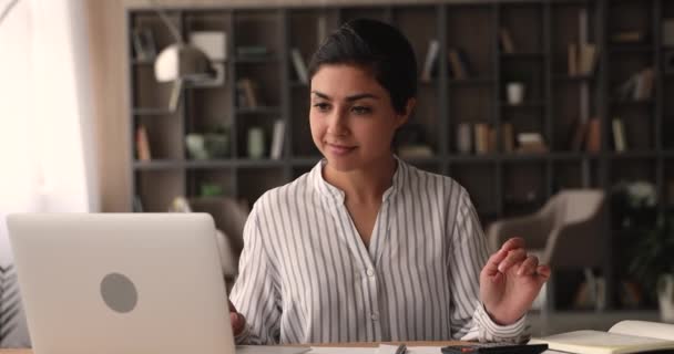 Ung indisk kvinna sitter vid skrivbordet använda kalkylator beräknar kostnader — Stockvideo