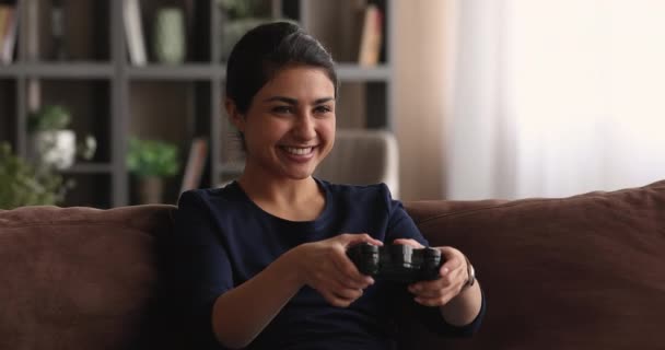 Indian woman holding game pad playing video games at home — Stock Video