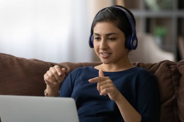 Yetenekli Hintli kadın öğretmen öğrenciye danışmak için bilgisayar kulaklığı kullanıyor.