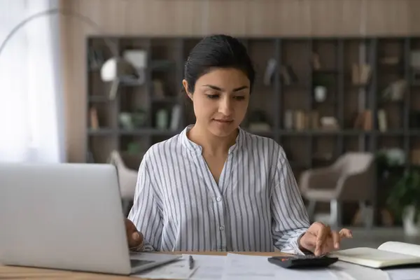 Indiase vrouwelijke auditor bereiden analytisch rapport met behulp van laptop handheld calculator — Stockfoto