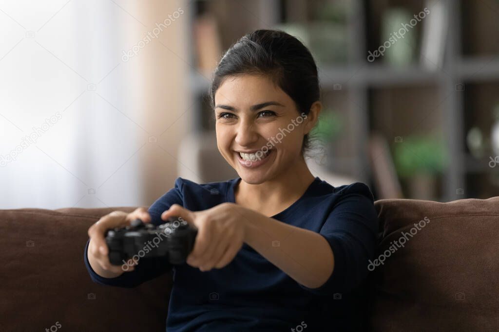 Passionate indian female teenager play favorite console videogame at home
