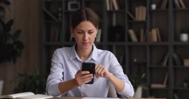 Elinde cep telefonu olan bir kadın çok kötü bir haber okuyor.