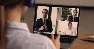 Grup video görüşmesine katılan iş adamları, iş kadını omzunun üzerindeki laptop ekranı