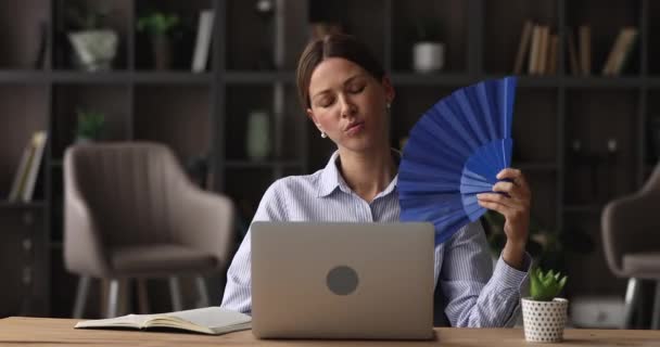 Vrouw gebruik blauw ventilator koelt zelf lijdt aan warmte indoor — Stockvideo