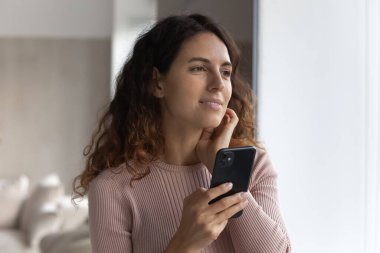 Düşünceli İspanyol kadın cep telefonuyla düşünüyor.