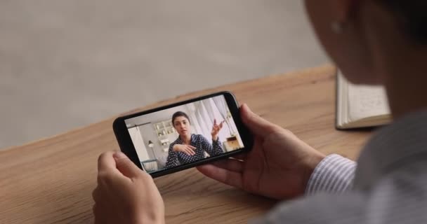 Mujer sentarse interior celebración smartphone participar en videocall con amigo — Vídeos de Stock