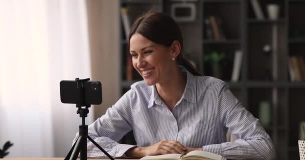Vrouw zet smartphone op statief praten door video oproep — Stockvideo