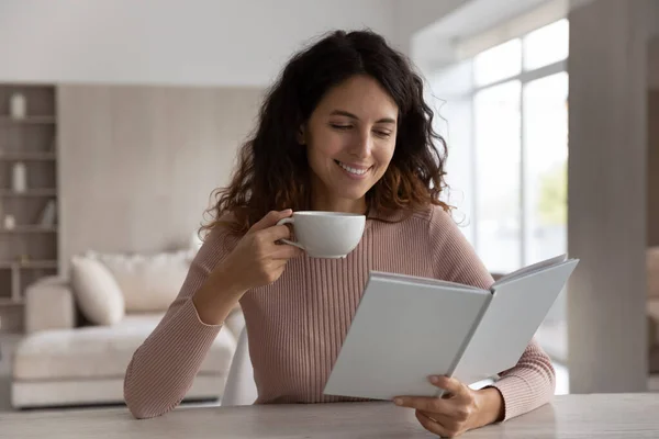 Smiling Latin woman drink book enjoying hot coffee — Stock Photo, Image