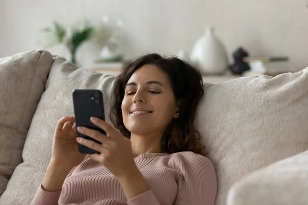 Mujer latina feliz relajarse en casa usando el teléfono celular — Foto de Stock