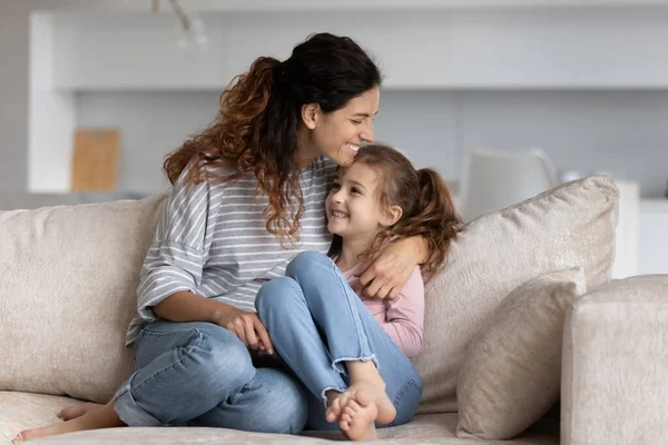 Sonriente mamá latina y su hija pequeña relajarse en casa — Foto de Stock