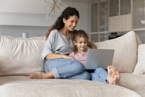 Glad latinamerikansk mamma och liten dotter använder laptop — Stockfoto