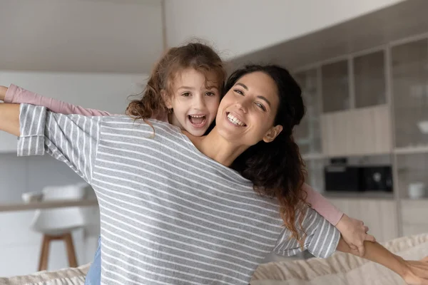 Portrait de heureuse maman hispanique et sa fille se détendre à la maison — Photo