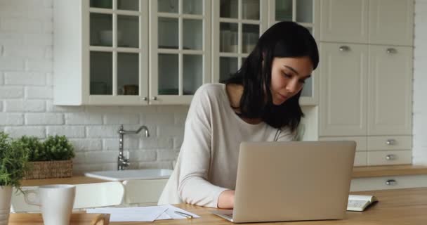 Joven sonriente Asiática mujer estudiando en casa usando portátil — Vídeo de stock