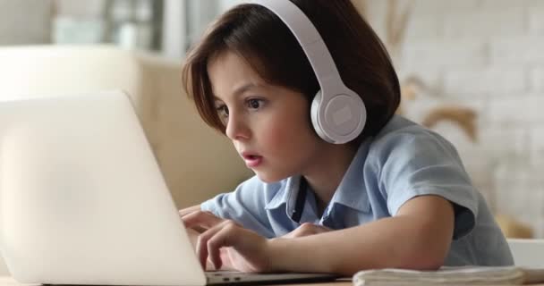 Chytrý malý 7s chlapec studující doma používat moderní techniku — Stock video