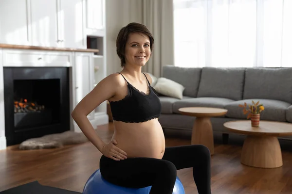 Retrato de mulher grávida sorridente sentada na bola em forma — Fotografia de Stock