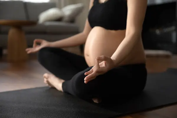 Close up donna incinta in abbigliamento sportivo nero praticare yoga, meditare — Foto Stock