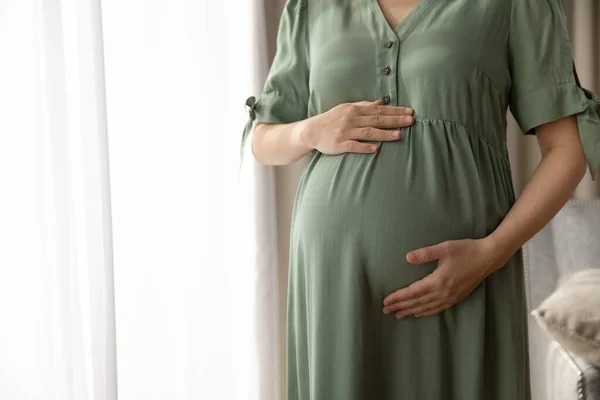 Närbild beskärs av gravid kvinna i klänning röra magen — Stockfoto